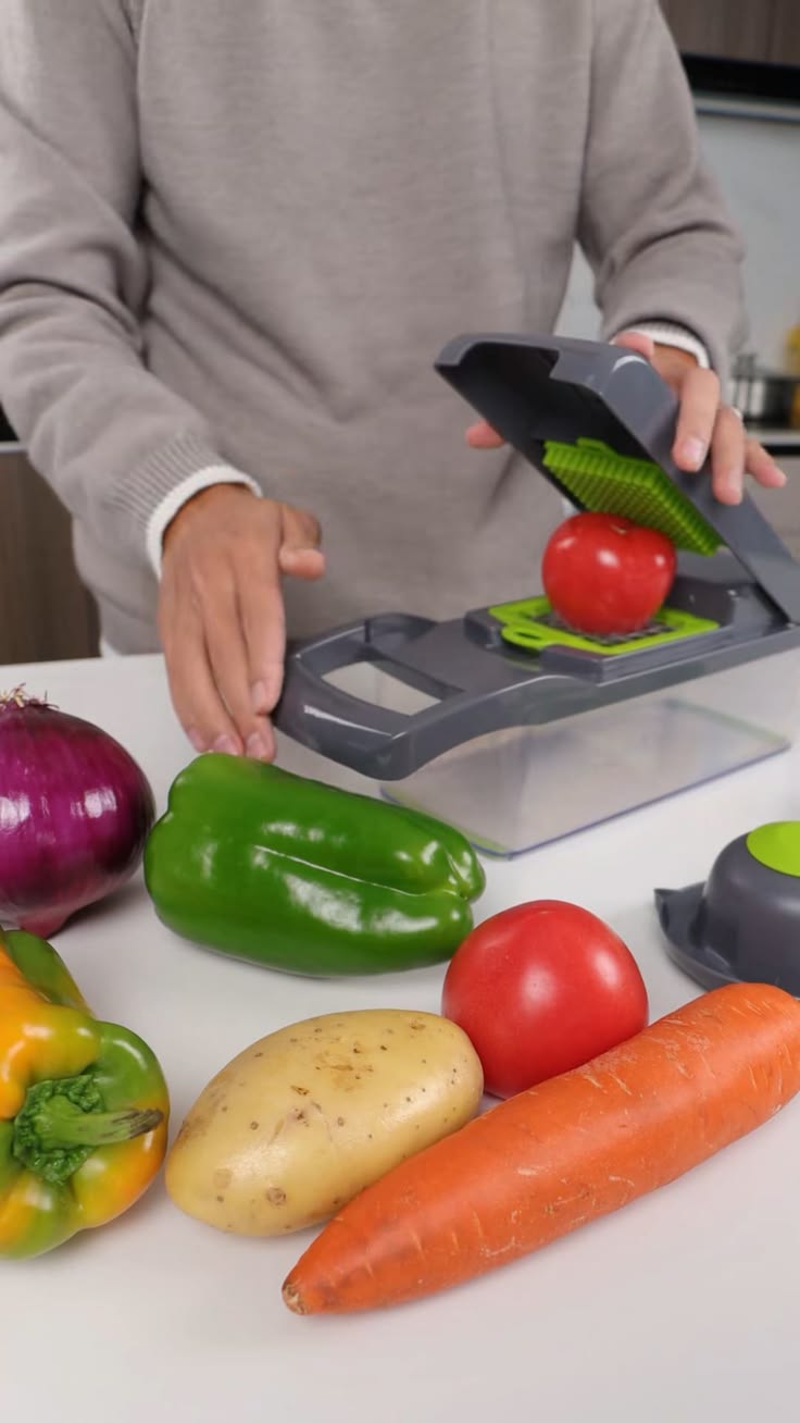 Grey 13-in-1 vegetable chopper slicing fresh onions and cucumbers into cubes
